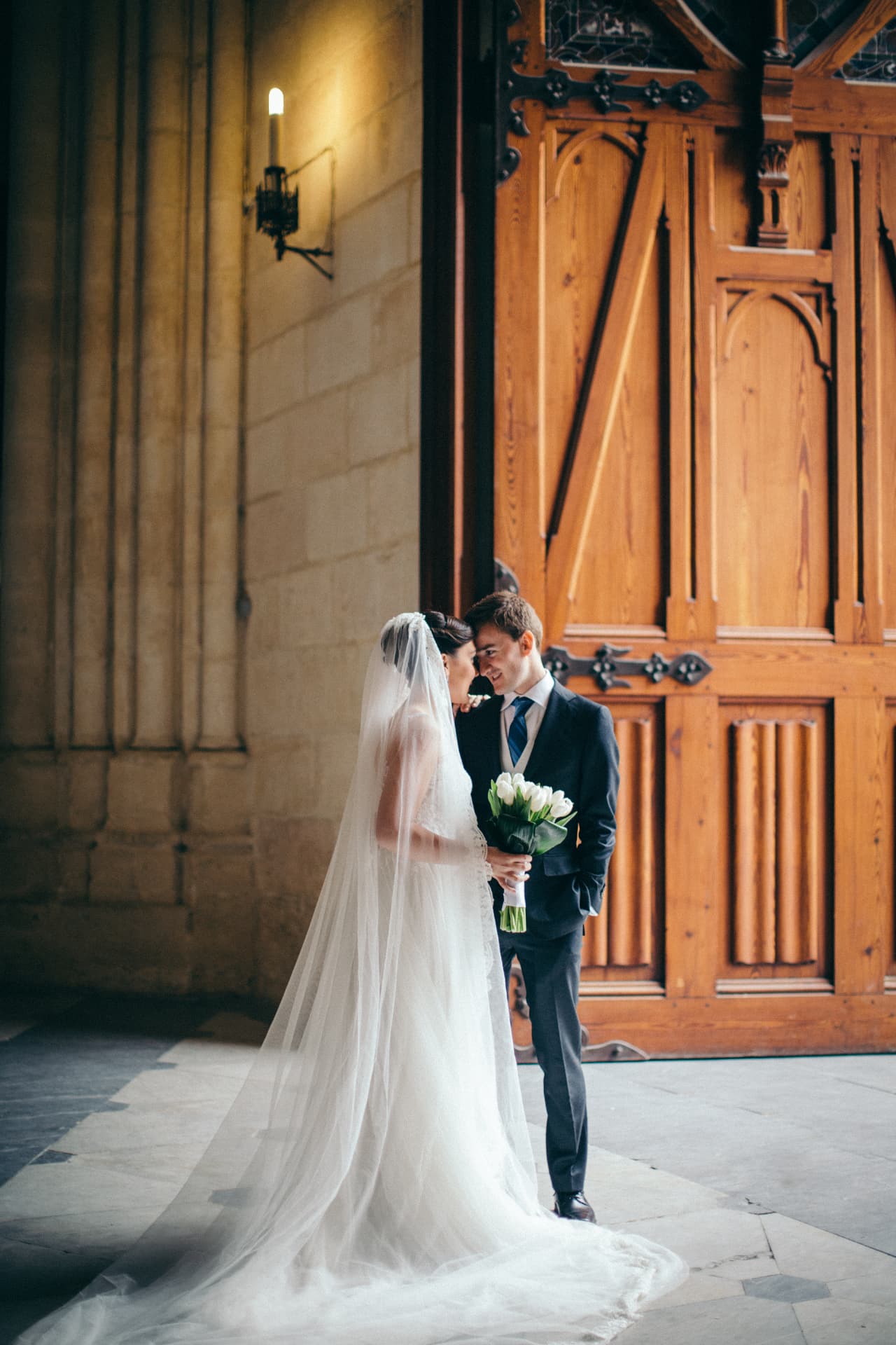 Bride and groom sharing a quiet moment beside cathedral doors